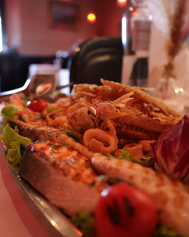 La frittura e la grigliata di mare servite in sala da Morgan's, con le lanterne rosse accese alle spalle